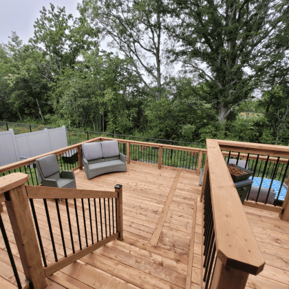 Multi-level large pressure-treated deck with black balusters in Almonte