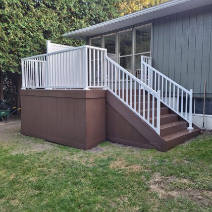 Brown composite back deck with white aluminum balusters off sliding doors in Kinburn