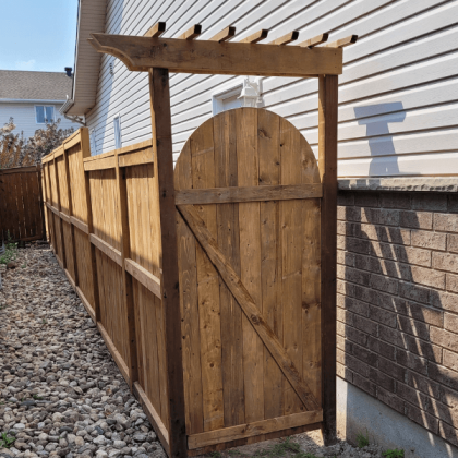 Pressure-treated backyard entrance gate between houses in Kanata