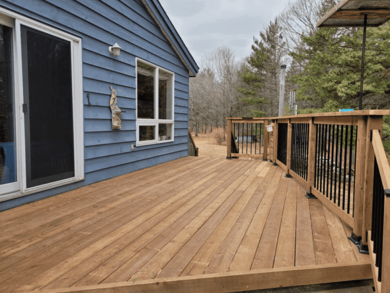 Resurfaced pressure-treated deck with black aluminum balusters in Almonte