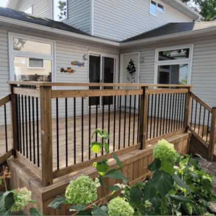 Pressure-treated deck with black aluminum balusters and two entrance steps in Almonte