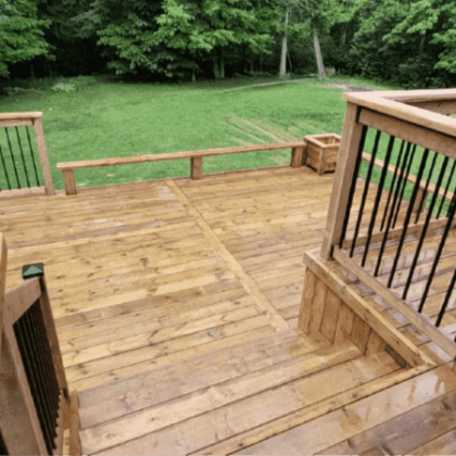 Pressure-treated multi-level deck with wraparound benches in Beckwith